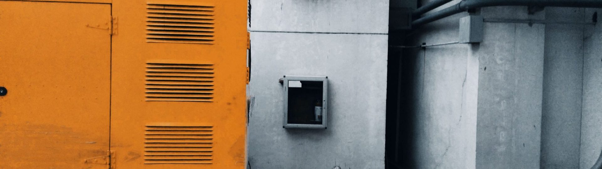 Silenced generator set beside an industrial building
